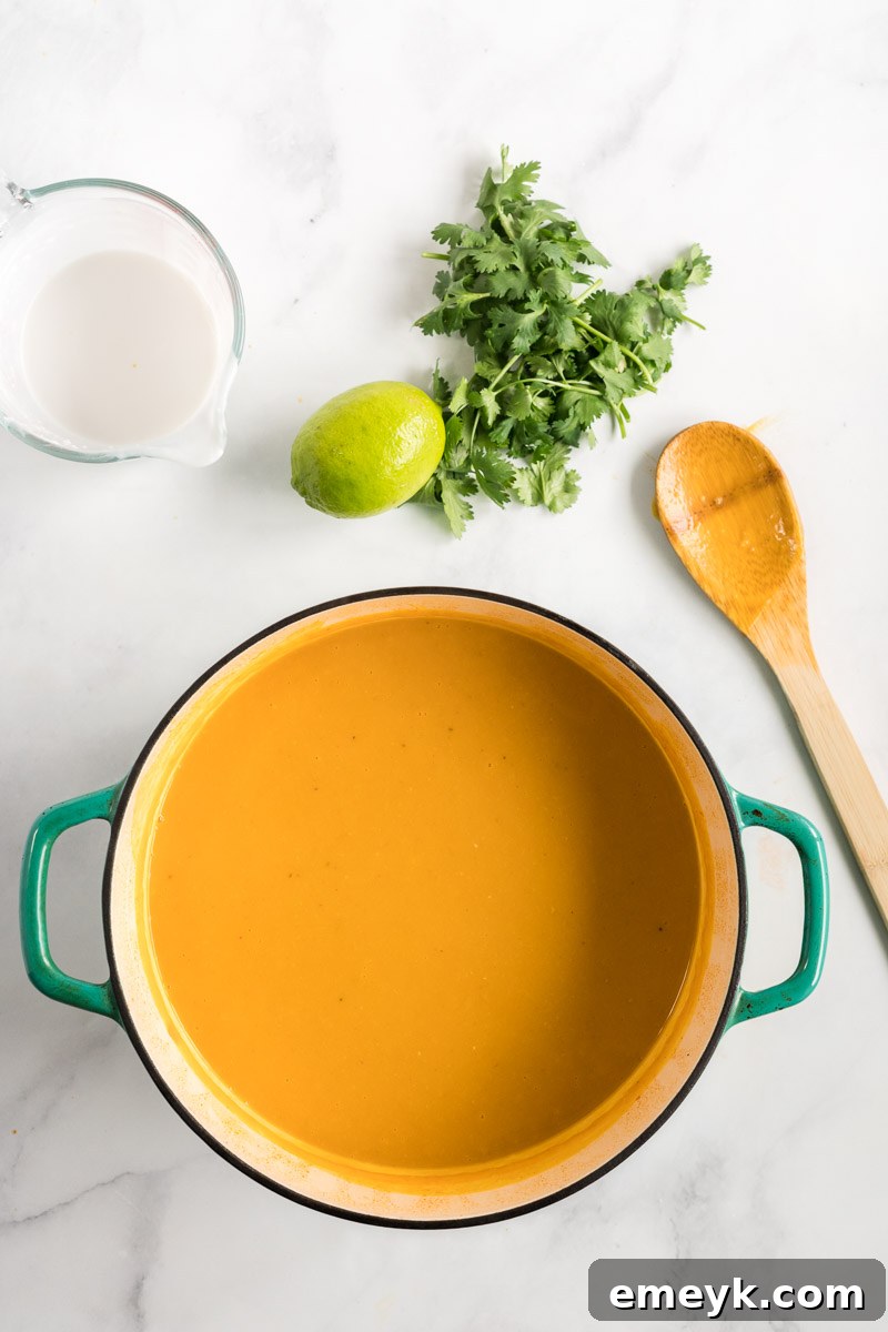 The Curried Butternut Squash Soup after being pureed to a smooth consistency in the pot using an immersion blender.