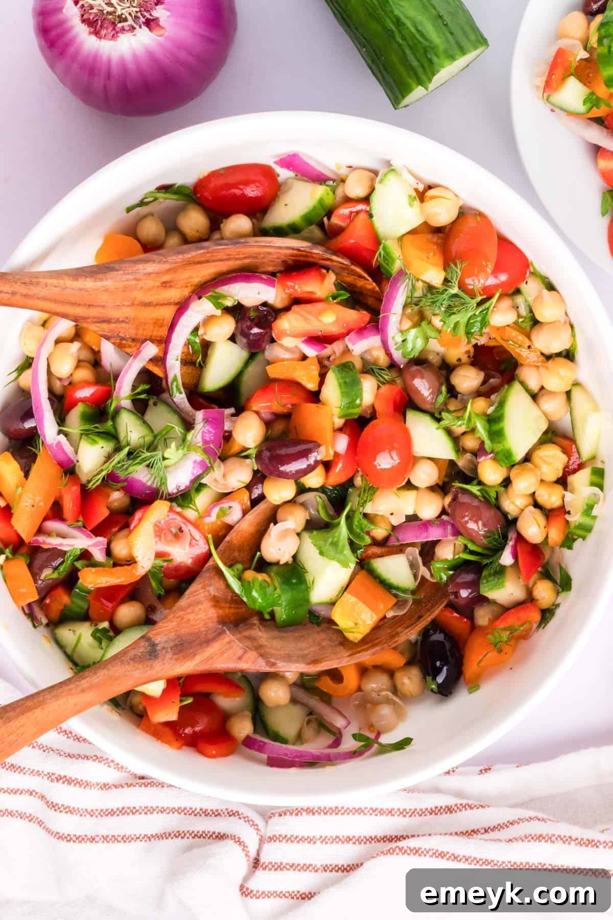 Mediterranean Chickpea Salad with two wooden spoons, showcasing vibrant colors and fresh ingredients