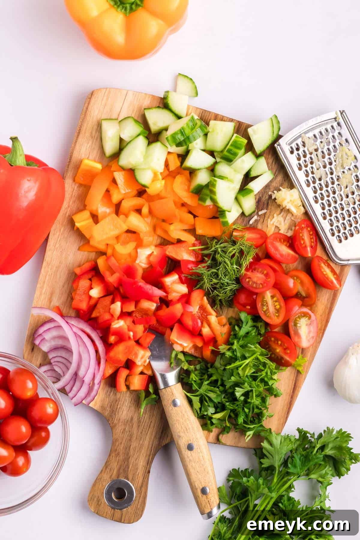 Mediterranean Chickpea Salad ingredients being chopped on a cutting board