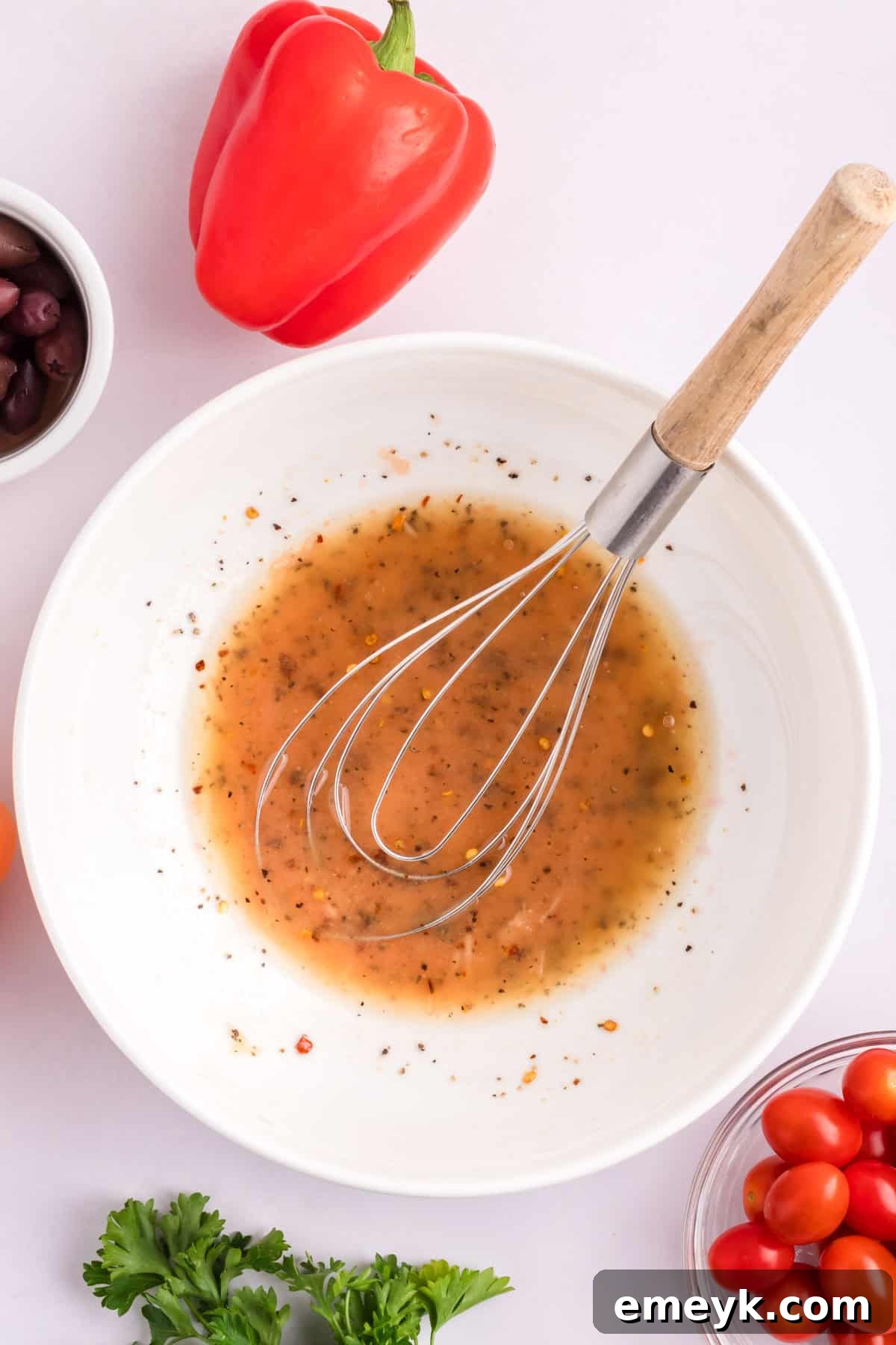 Mediterranean Chickpea Salad with dressing in a bowl, ready to be mixed.