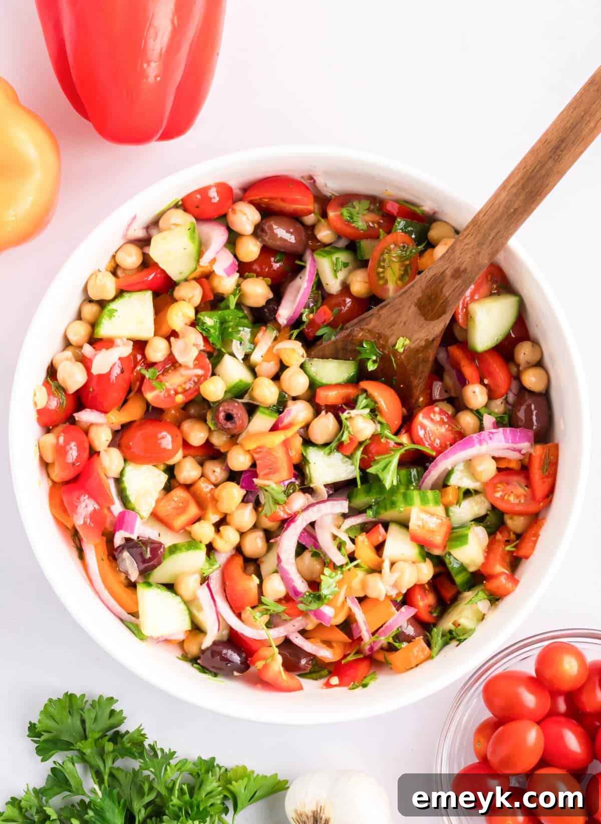 Mediterranean Chickpea Salad with spoon, in a white bowl