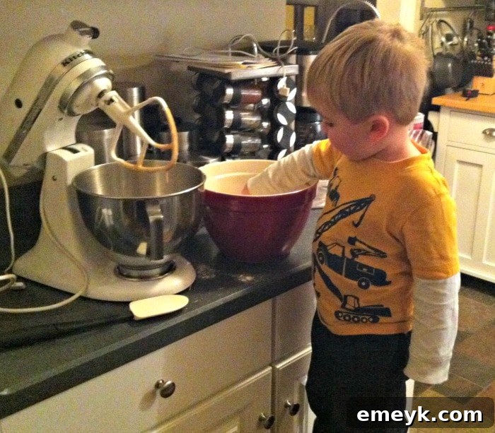 Young child, named Will, enthusiastically mixing ingredients in a bowl, actively participating in kitchen activities.