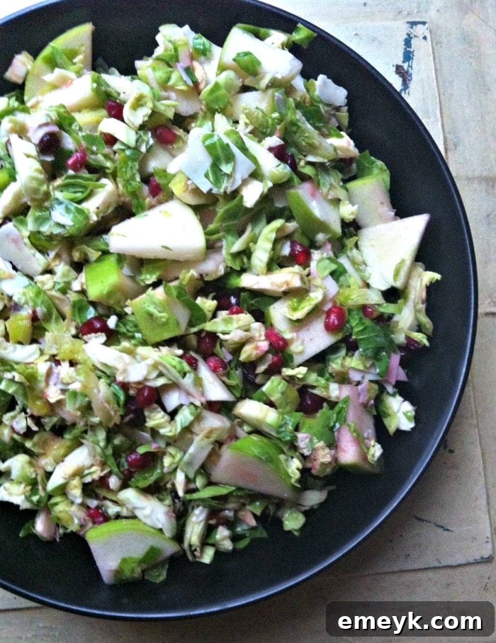 A close-up shot of a healthy Shaved Brussels Sprout Salad, highlighting the crisp texture of the shaved sprouts and the vibrant colors of the other ingredients.