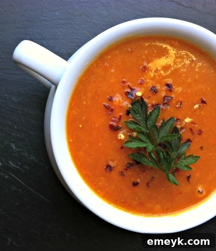 Vibrant Red Lentil Coconut Soup 4 A close-up of Red Lentil Coconut Soup simmering in a Dutch oven, showing its rich texture and inviting color.