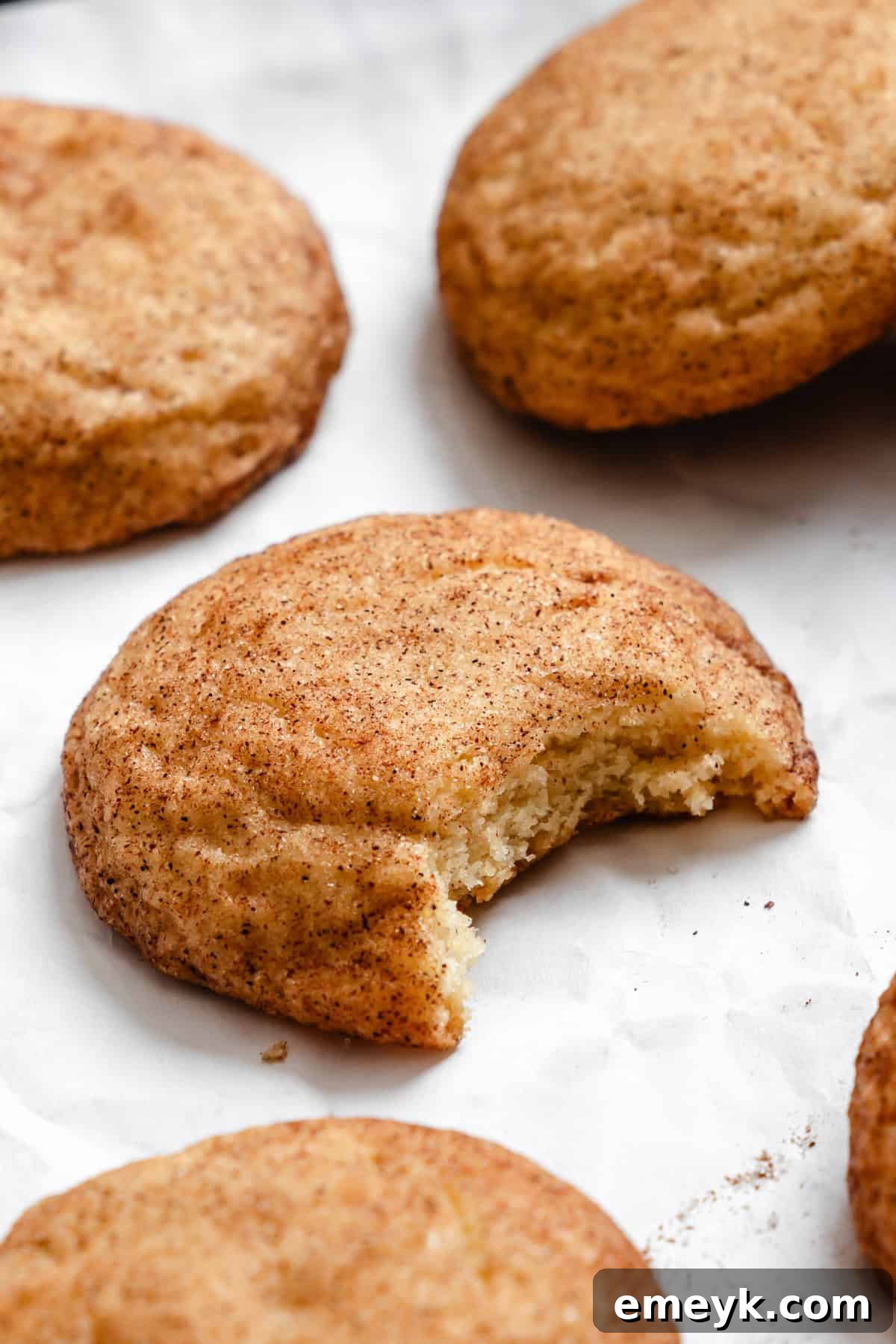 Easy Snickerdoodle Recipe with a bite taken out, revealing its soft and chewy interior.