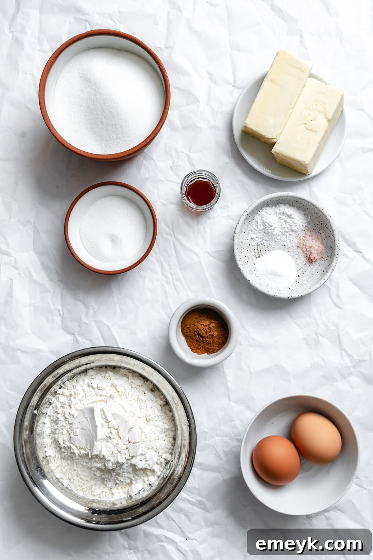 Easy Snickerdoodle Recipe ingredients laid out on a table, including butter, sugar, eggs, flour, and spices.