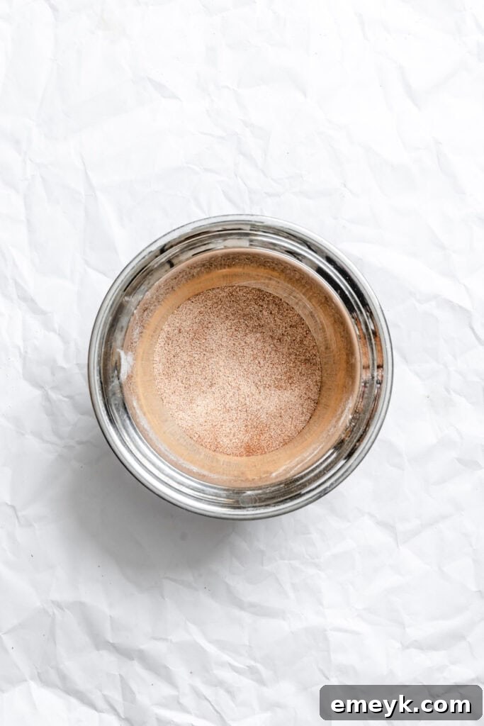 Easy Snickerdoodle Recipe showing the cinnamon and sugar mixture prepared in a small bowl for coating.