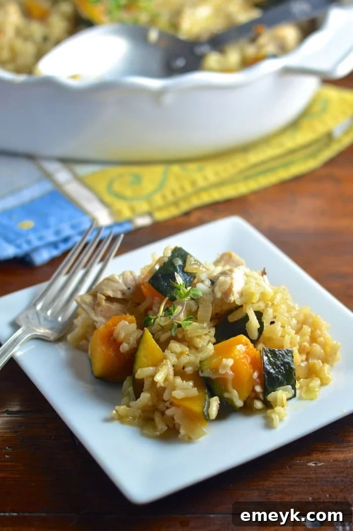 A serving of Baked Chicken Kabocha Squash Risotto Recipe on a white plate, garnished with fresh thyme.