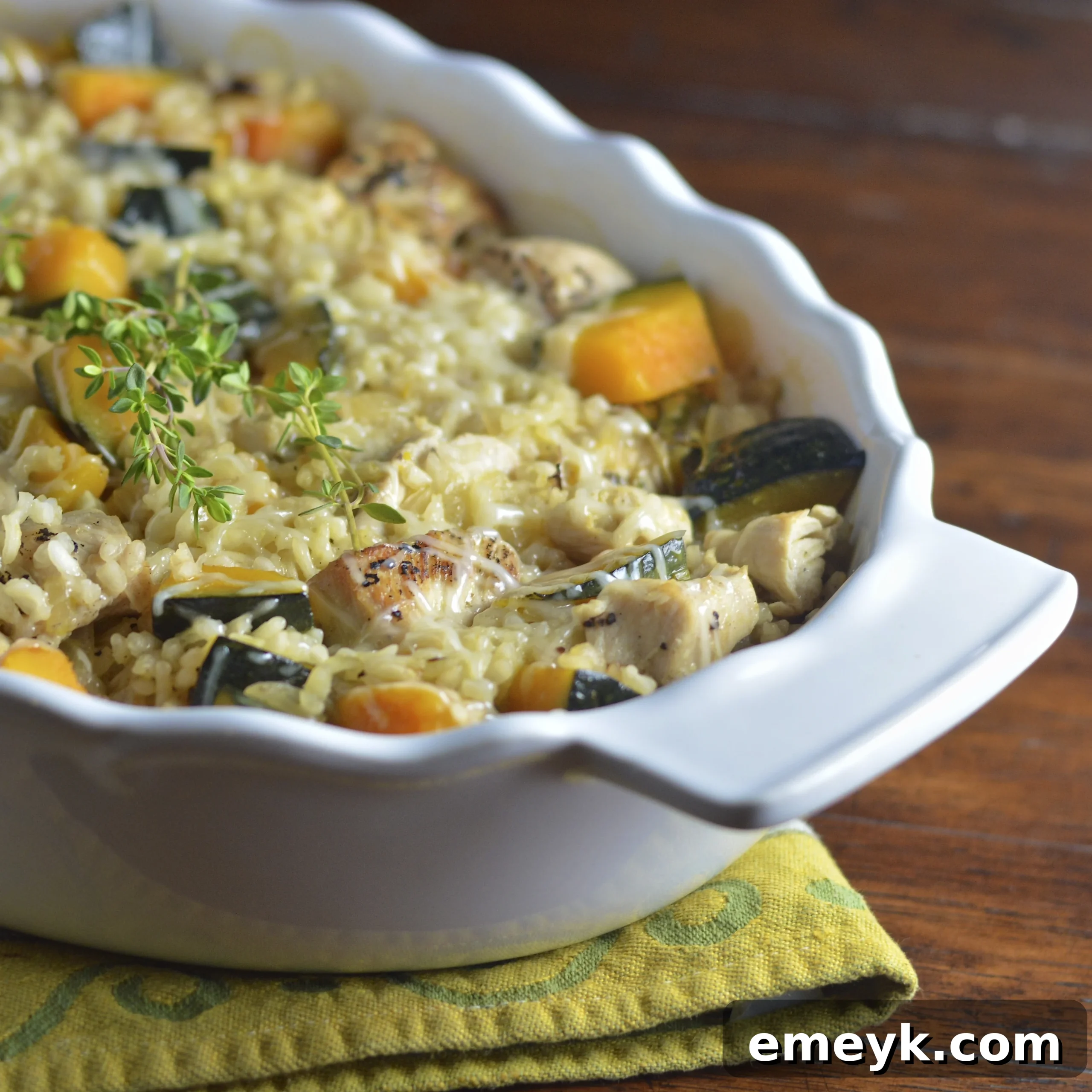 A cozy scene featuring a white casserole dish of Baked Chicken Kabocha Squash Risotto Recipe on a yellow napkin, ready to be served.