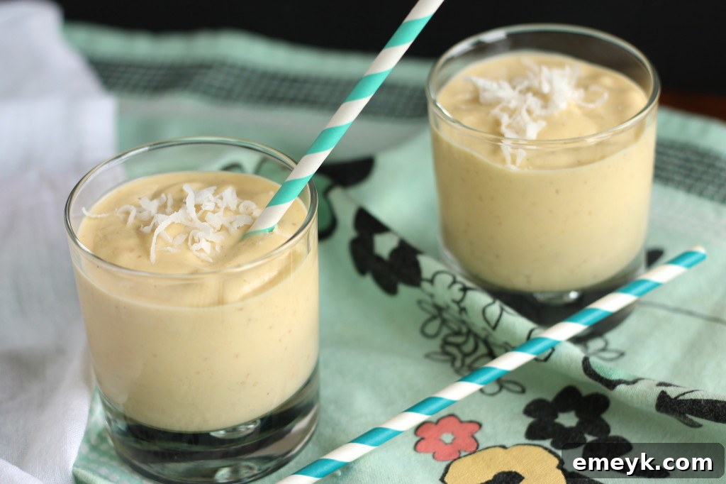 Mango Coconut Paradise 3 Freshly blended Coconut Mango Smoothie in a glass, ready to be enjoyed.