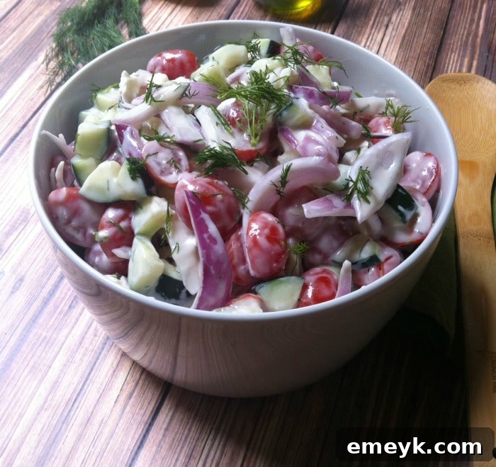 Close-up of the dill yogurt dressing being poured over the fresh salad ingredients