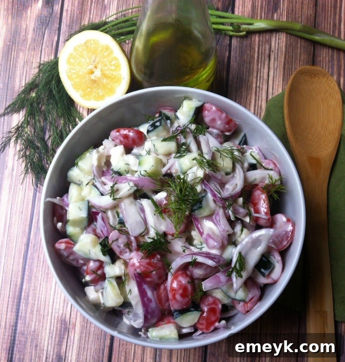Freshly prepared Cucumber Tomato Salad with a generous swirl of dill yogurt dressing