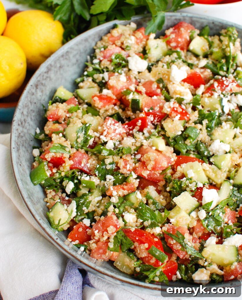 A blue bowl filled with fresh chopped tomatoes, cucumbers, and crumbled feta cheese, waiting to be mixed into a salad.