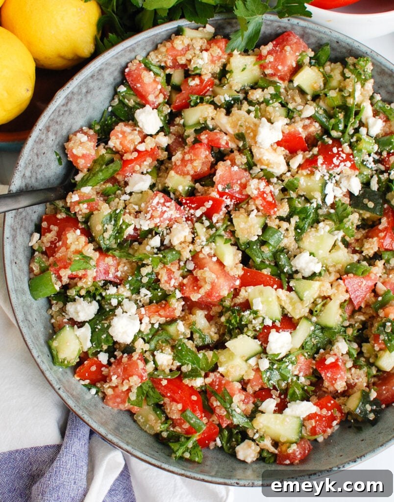 A large, colorful bowl of Tomato Cucumber Feta Quinoa Salad, ready to be served, showcasing its vibrant ingredients.