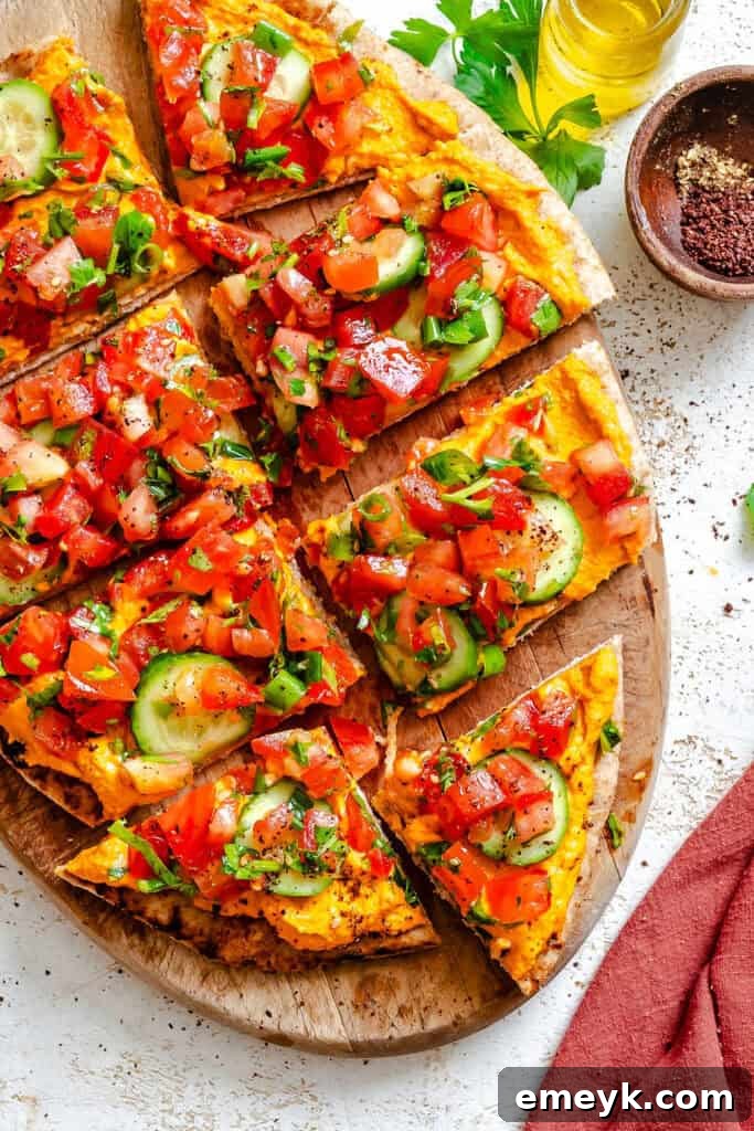 Mediterranean Naan Pizza on a wooden plate, garnished with fresh herbs