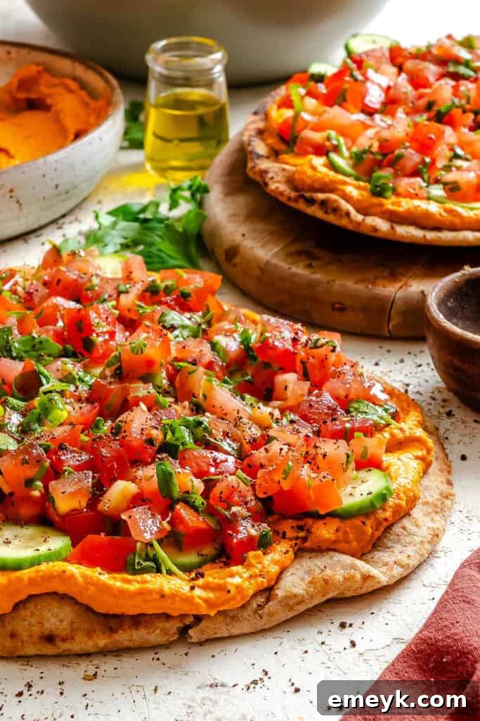 Mediterranean Naan Pizza on a cutting board, garnished with fresh parsley and a sprinkle of sumac