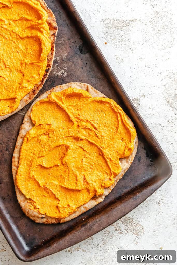Toasted naan bread with a generous layer of hummus spread evenly