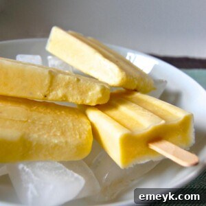 A vibrant homemade Pina Colada popsicle, capturing the essence of tropical flavors with its creamy texture and refreshing appeal.