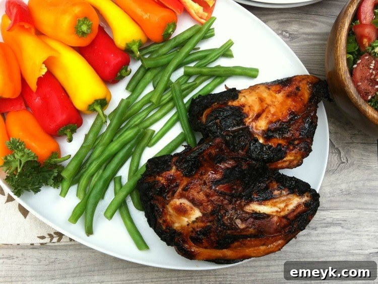 Spiced Honey-Lime Glazed Grilled Chicken 3 Two pieces of Spiced Honey Lime Grilled Chicken served with fresh green beans and a lime wedge on a rustic plate.