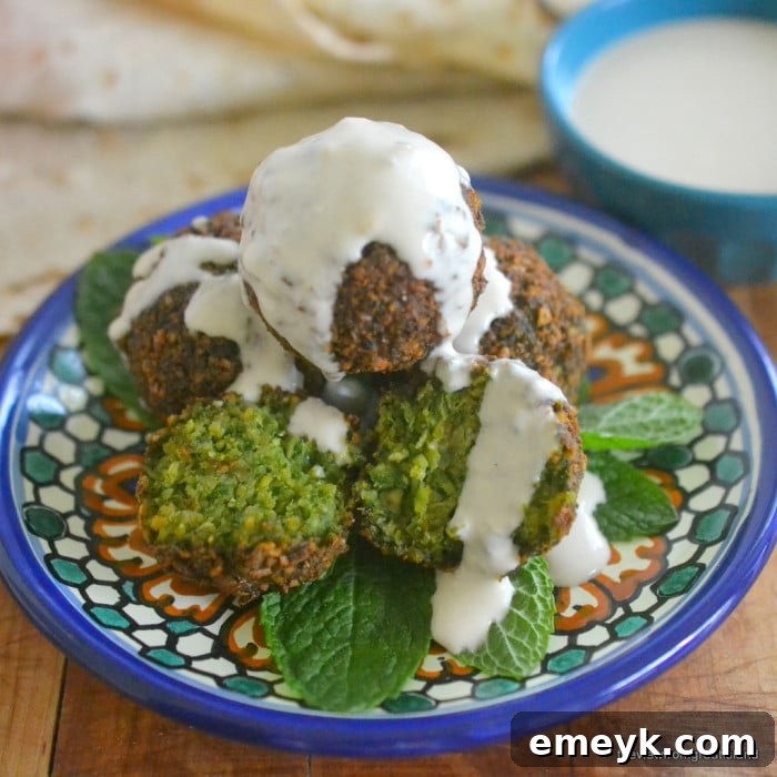 A close-up of golden brown, crispy falafel served with fresh herbs, a quintessential Middle Eastern vegetarian delight.