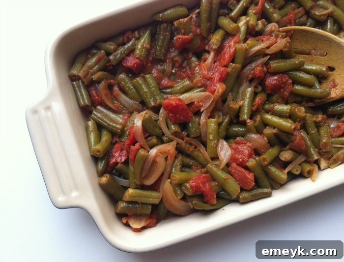 A close-up of vibrant Lebanese Green Beans (Lubee), slow-cooked in a rich tomato sauce with garlic and olive oil, a wholesome and flavorful vegetarian dish.