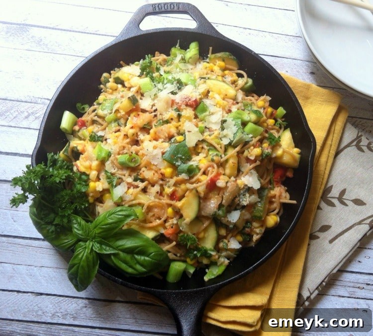 A close-up shot of the fresh, vibrant ingredients for Garden Pasta Skillet laid out on a cutting board, including zucchini, tomatoes, corn, and garlic, ready for preparation.