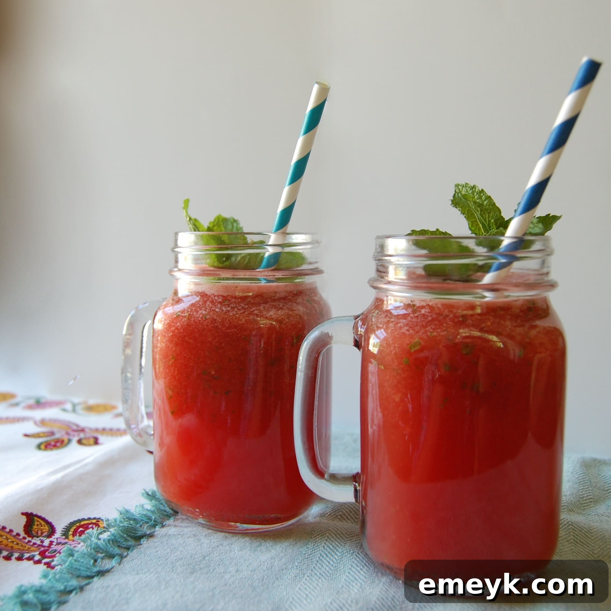Refreshing Watermelon Lemonade Slushy in a glass, garnished with fresh mint and a watermelon wedge
