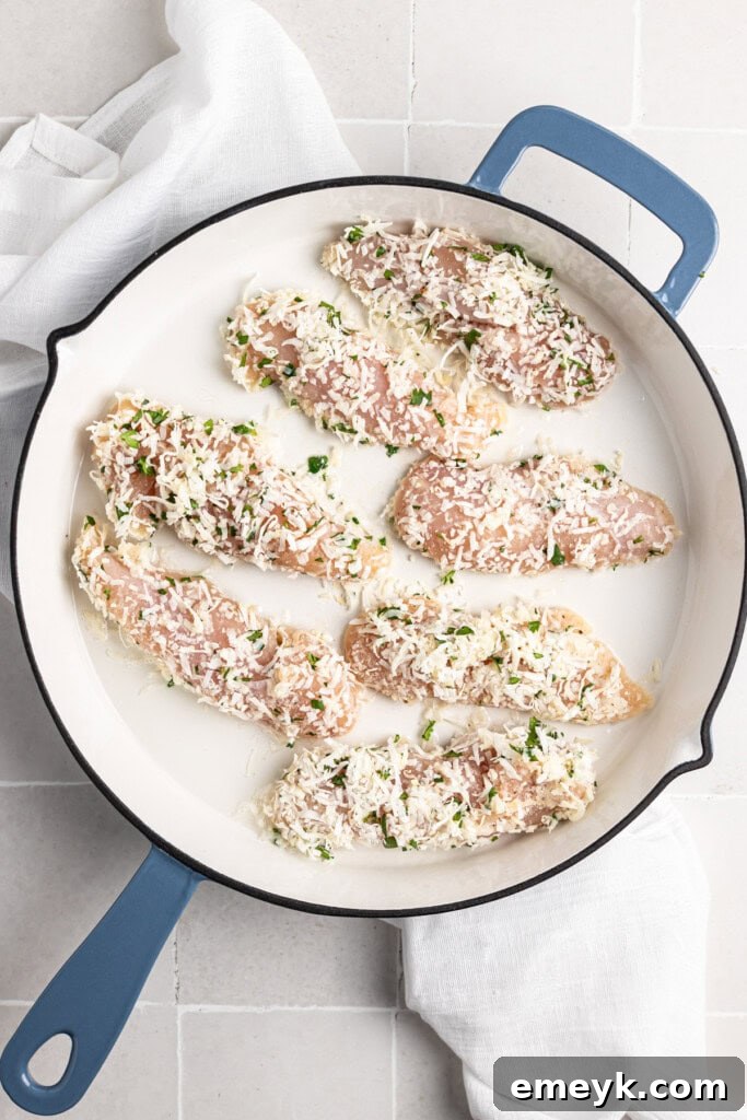Golden Crispy Baked Coconut Chicken Tenders Kids Love 8 Crispy Coconut Chicken Tenders cooking in a large skillet, browning to a golden crisp.