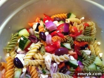 Mixed Greek Pasta Salad Freshly mixed Greek Pasta Salad in a large bowl, ready for chilling