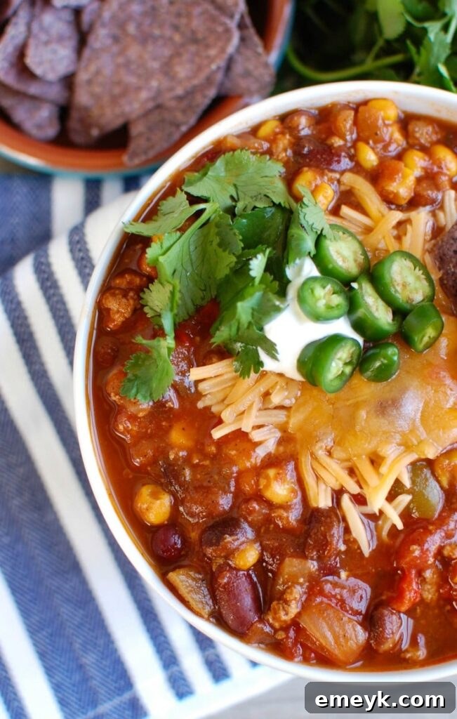 Hearty Slow Cooked Turkey Chili 3 A bowl of Slow Cooker Turkey Chili, garnished with fresh cilantro and lime wedges, showcasing its vibrant ingredients.