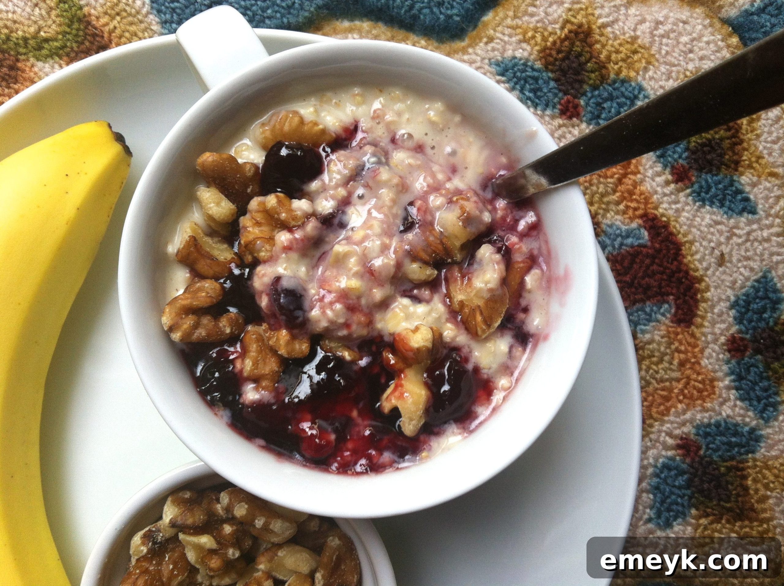 Close-up of a spoonful of Cherry Overnight Oatmeal, showing layers of oats, yogurt, and cherry swirls in a jar