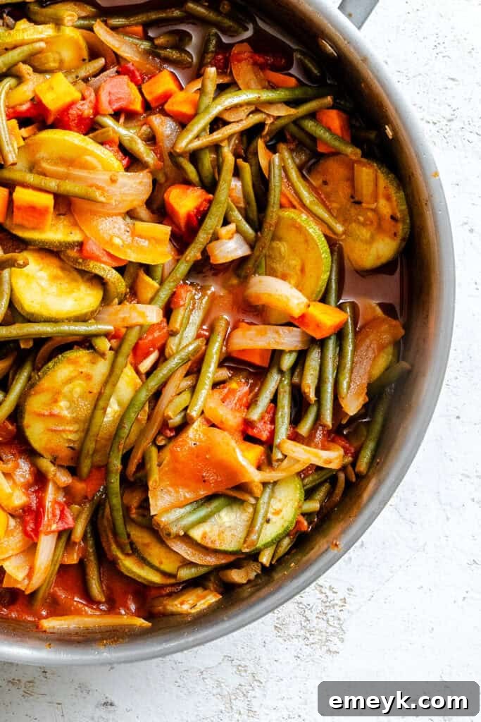 Lebanese Vegetables simmering in a pot with a tilted lid, allowing steam to escape, illustrating the slow cooking process.