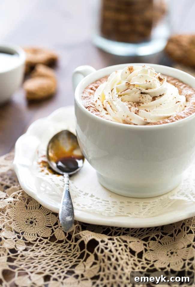 41 Festive Season Sips 4 A tall glass of Ginger Snap Cookie Steamer, topped with whipped cream and a sprinkle of cinnamon, evoking warm holiday spices.