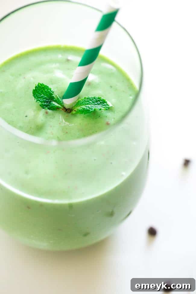 41 Festive Season Sips 10 A refreshing Mint Chocolate Green Smoothie in a tall glass with a straw, a healthy and festive beverage option.