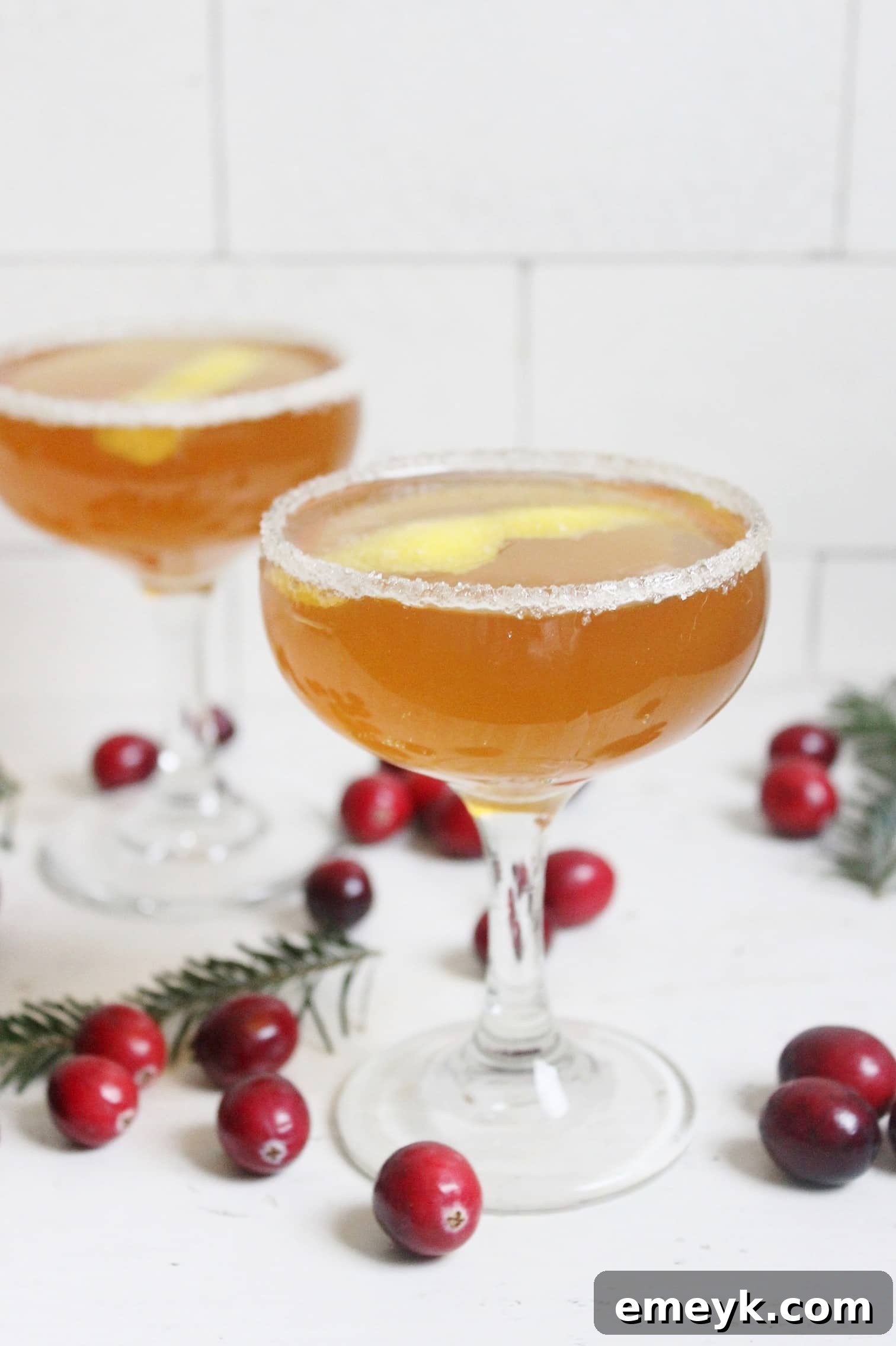 41 Festive Season Sips 7 An elegant Earl Grey French 75 cocktail in a champagne flute, garnished with a lemon twist, featuring a delicate floral aroma.