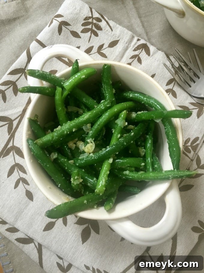 Deliciously Simple Garlic Parmesan Green Beans with a vibrant green color, generously sprinkled with cheese