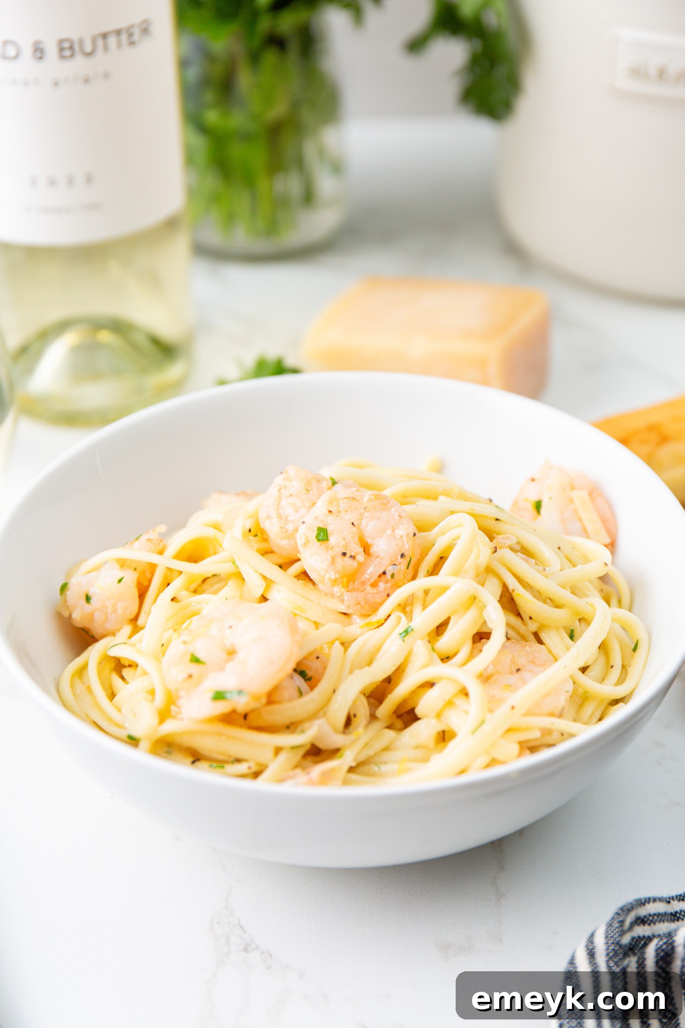 Lemon Garlic Shrimp Pasta served with a glass of white wine and fresh lemon wedges, ready to be enjoyed.