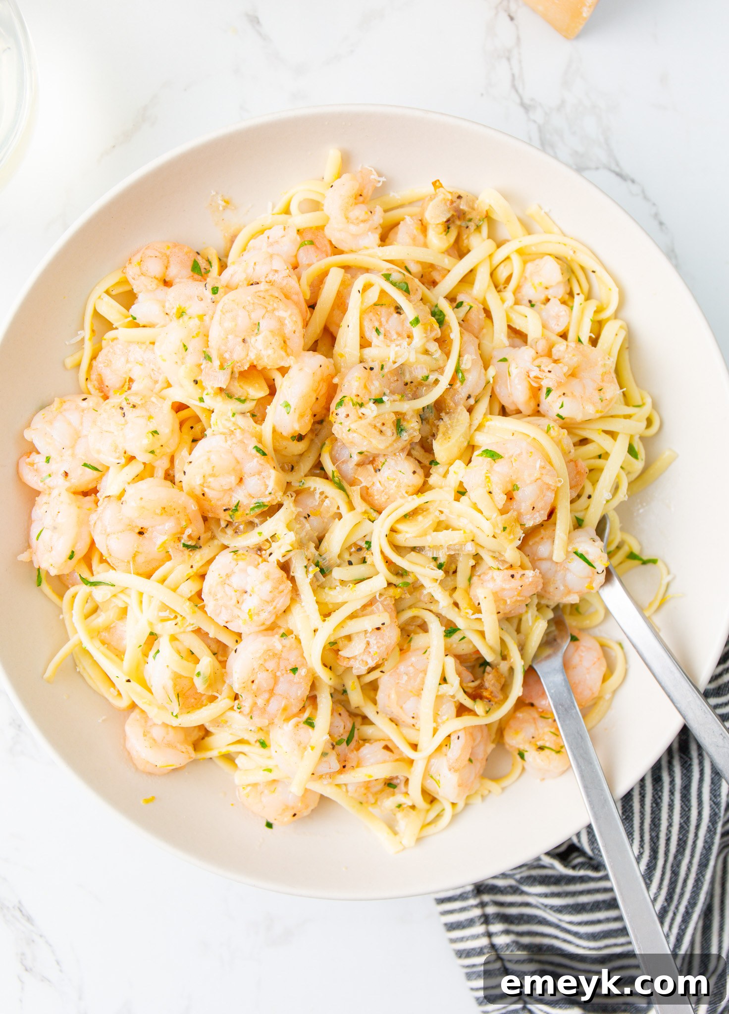 A bowl of freshly cooked Lemon Garlic Shrimp Pasta, garnished with fresh parsley and lemon slices.