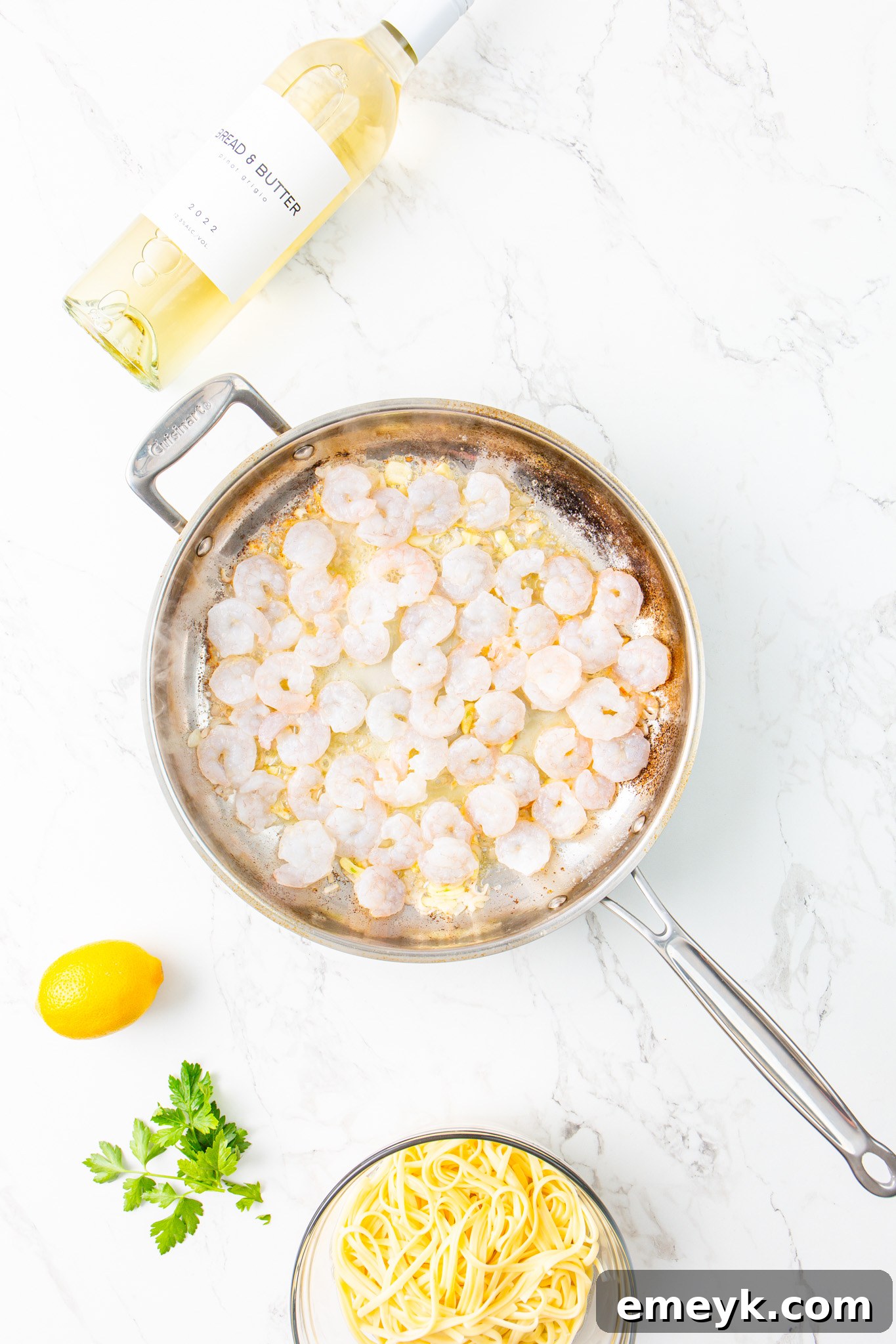 Shrimp cooking in a skillet with garlic and onion for the Lemon Garlic Shrimp Pasta.