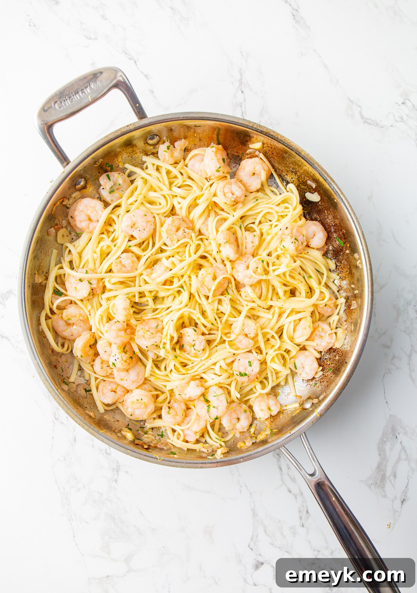 Lemon Garlic Shrimp Pasta being tossed in a large skillet, ready to serve.