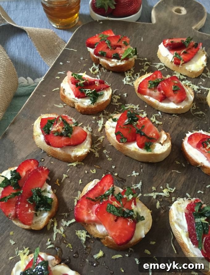 Velvet Strawberry Crostini with Mint and Zesty Honey 2 Close-up of Strawberry Mint Crostini with Lemon Honey Drizzle, showcasing fresh strawberries and mint on creamy mascarpone.
