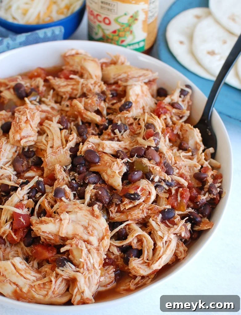 Set It and Forget It Shredded Chicken 2 Slow Cooker Shredded Chicken in a white bowl, garnished with cilantro
