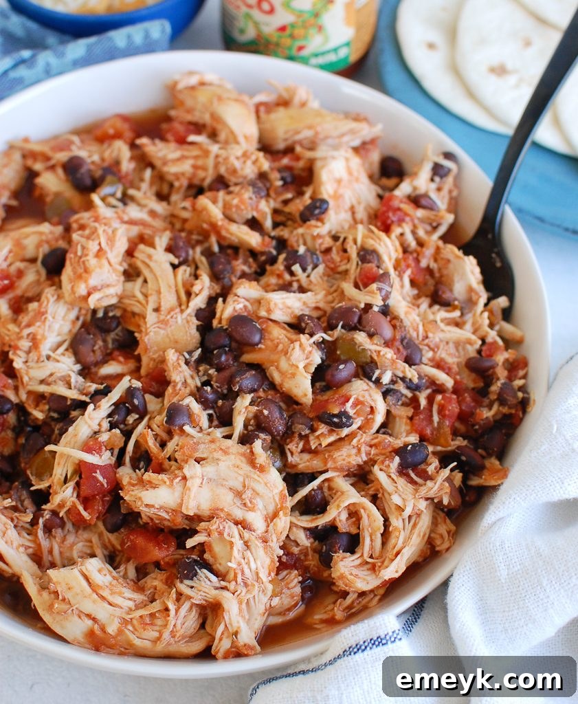 Set It and Forget It Shredded Chicken 5 Slow Cooker Shredded Chicken in a bowl with a teal napkin