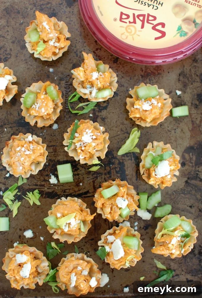 Overhead shot of several Buffalo Chicken Hummus Bites on a baking sheet, showing their even golden color.