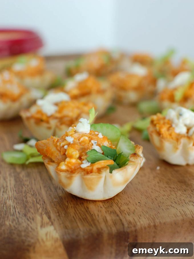 Hand holding a single Buffalo Chicken Hummus Bite, highlighting its delicate crust and filling.