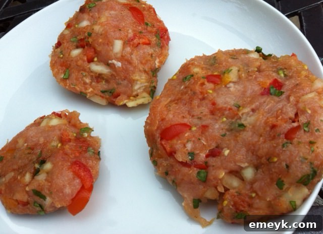 Several uncooked turkey burger patties, uniformly shaped and ready for grilling, displayed on a surface