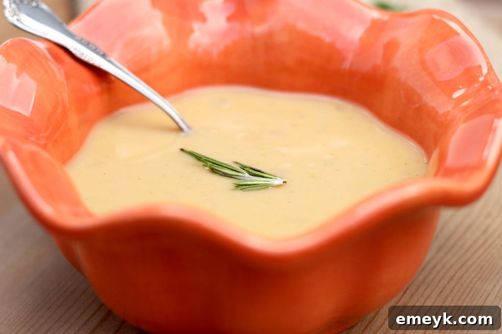 Rustic Roasted Garlic and Rosemary White Bean Soup, garnished with fresh herbs.