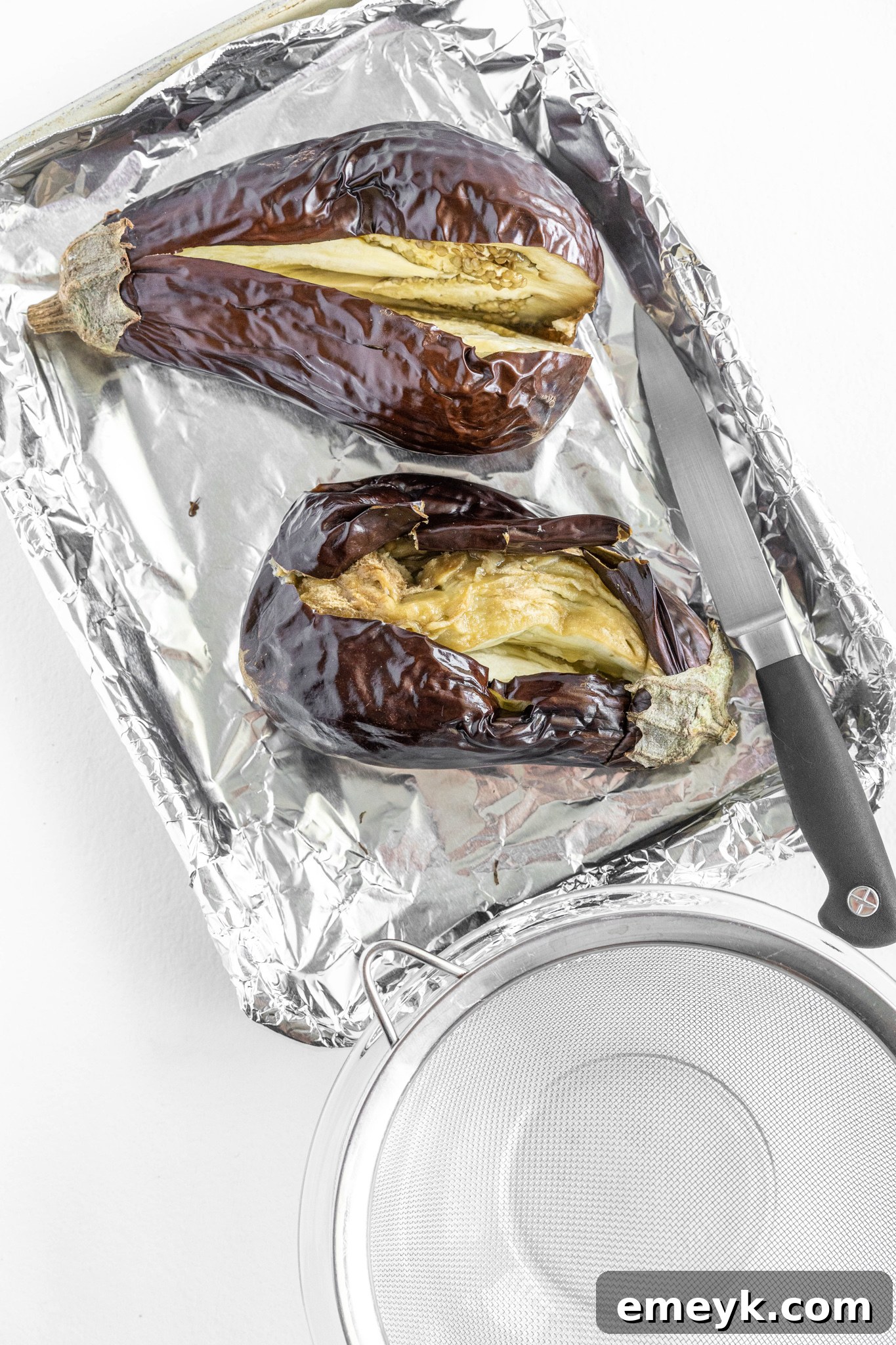 Scooping out the soft, roasted eggplant flesh for Baba Ghanoush.