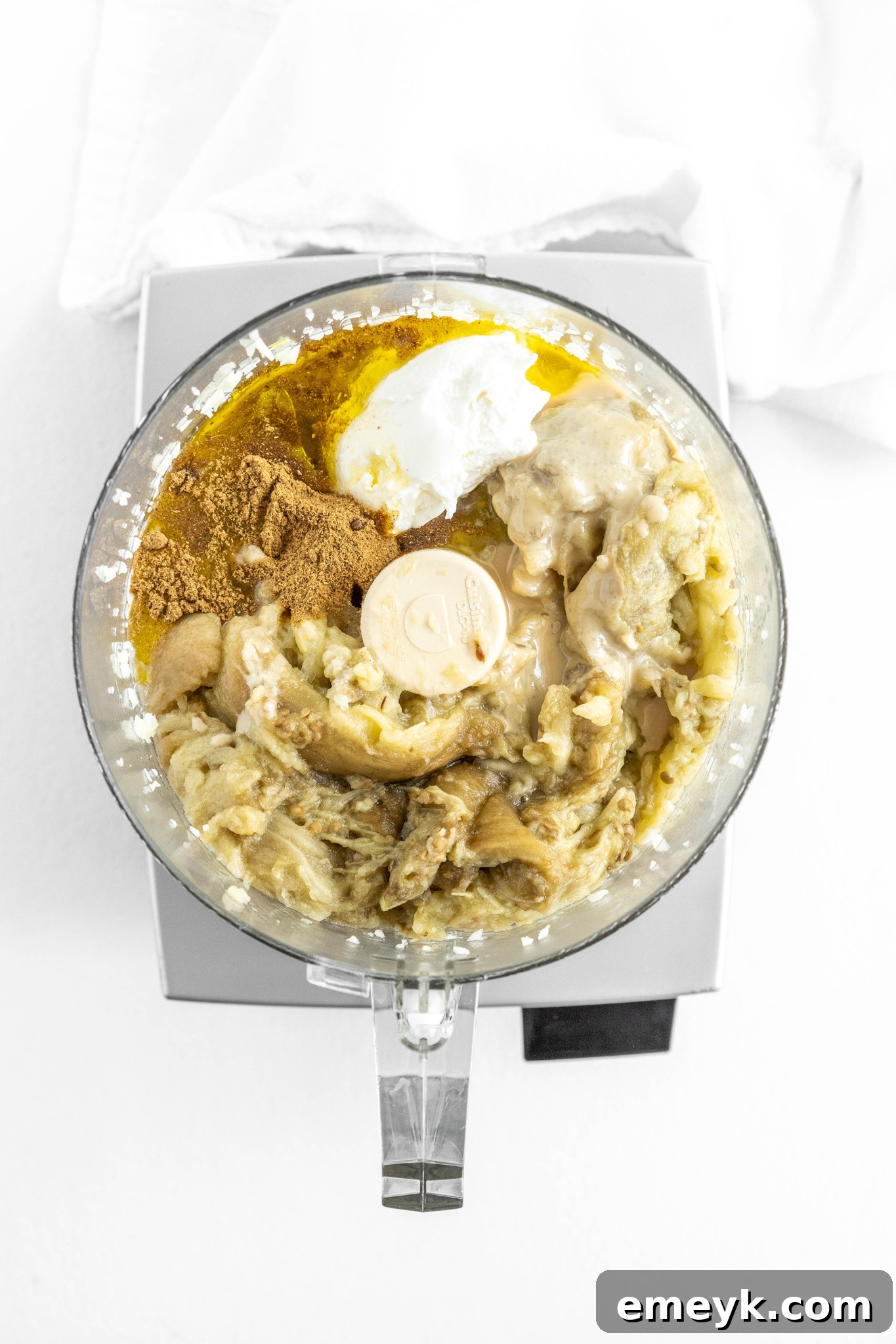 Ingredients for Baba Ghanoush blending in a food processor.