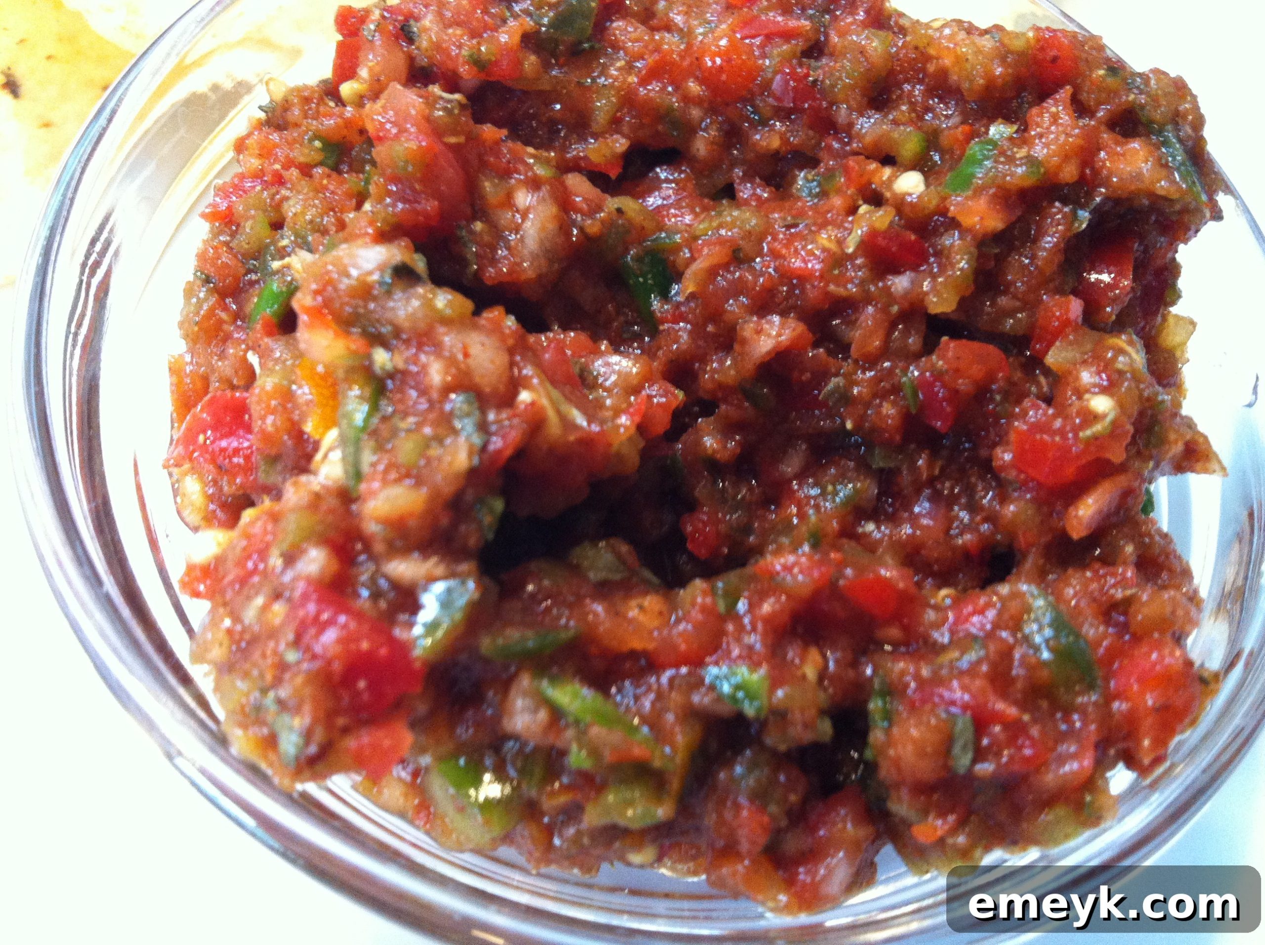 A bowl of freshly made Kickin' Salsa ready to be enjoyed, garnished with fresh herbs.